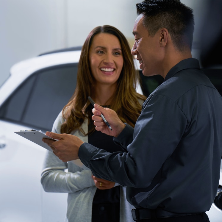 Asesor de ventas atendiendo a una clienta en una concesionaria